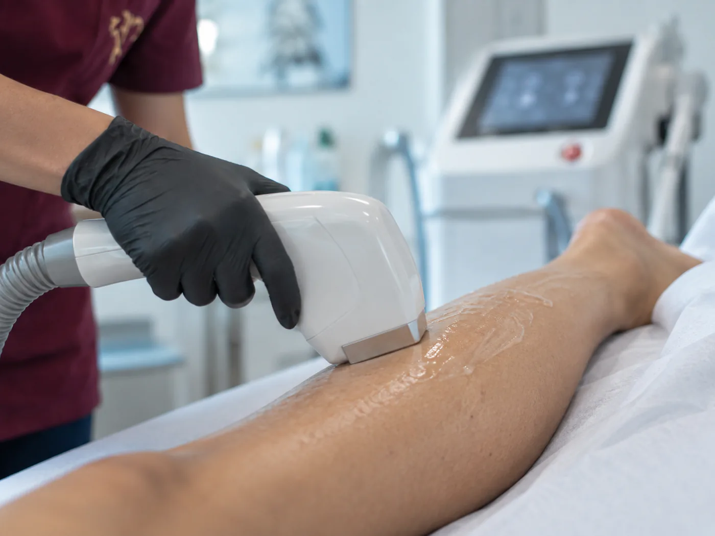 Il manipolo del laser diodo su una zona del corpo, durante una seduta reale in clinica.